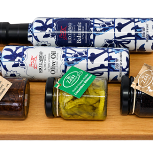 Gourmet gift tray with olive oil, balsamic vinegar and savoury preserves on a wooden serving tray