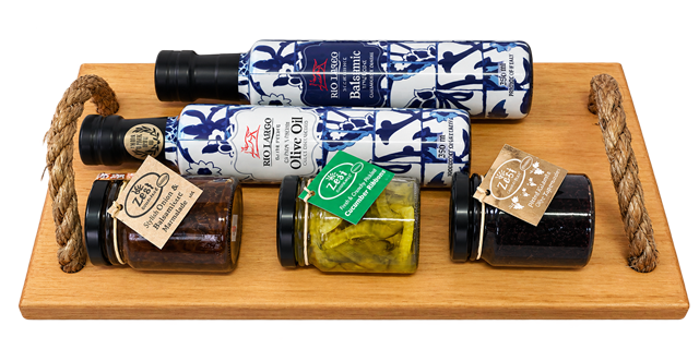 Gourmet gift tray with olive oil, balsamic vinegar and savoury preserves on a wooden serving tray