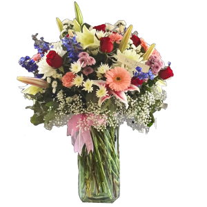 Seasonal mix of pink and red flowers in glass vase by Eros Florist