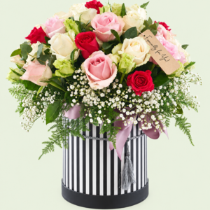 Shades of pink and cream roses in a black and white striped hatbox