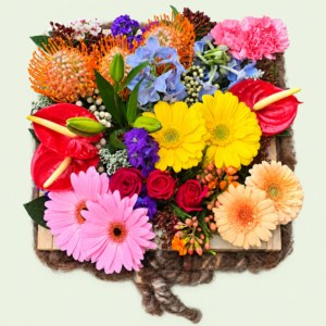 Order Splash of Colour from Eros Florist. A bright seasonal flower arrangement in a wooden tray, made fresh for delivery in Pretoria.