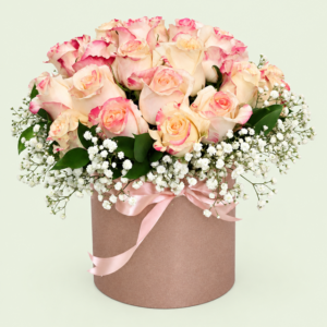 Blushing Fragrance hatbox arrangement with fragrant cream roses edged in pink, white gypsophila and greenery from Eros Florist Pretoria.